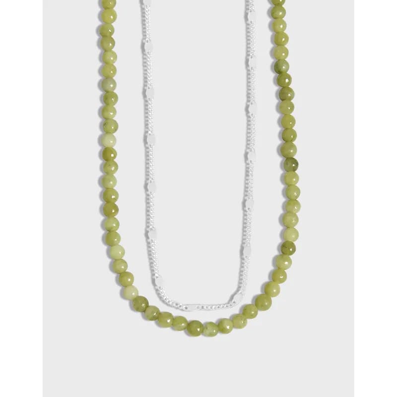 Long two-strand necklace with olive-green beads and a silver disc-link chain.