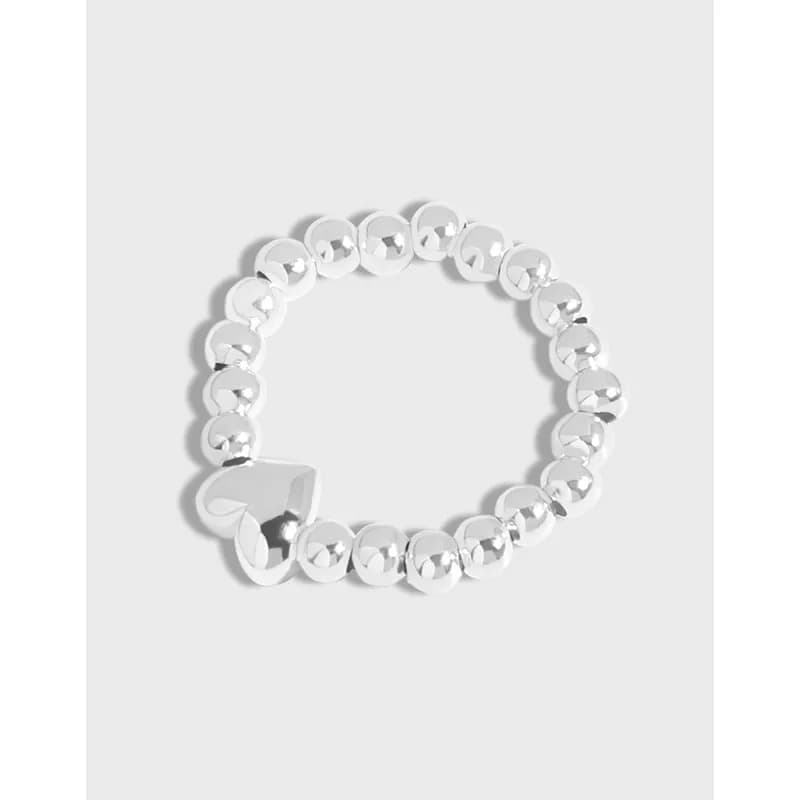 Polished sterling silver beaded ring with a small heart charm at the front