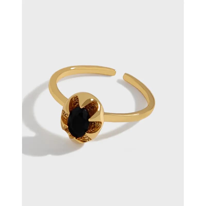 Polished sterling silver ring with a small flower motif and black central stone