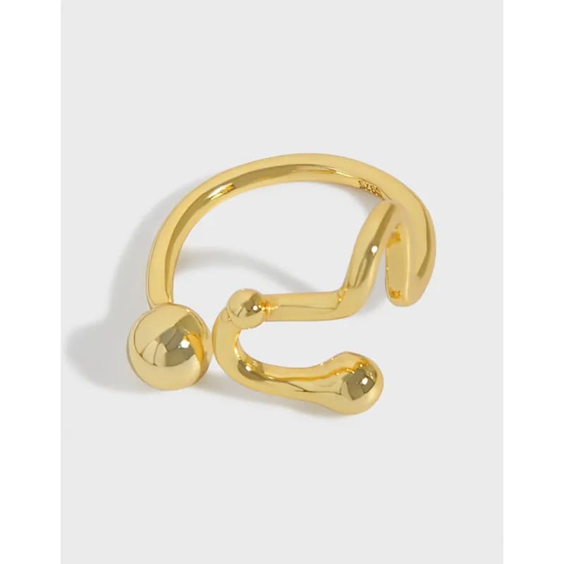 Gold-tone open-wrap sterling silver ring with two spherical ends on a light background.