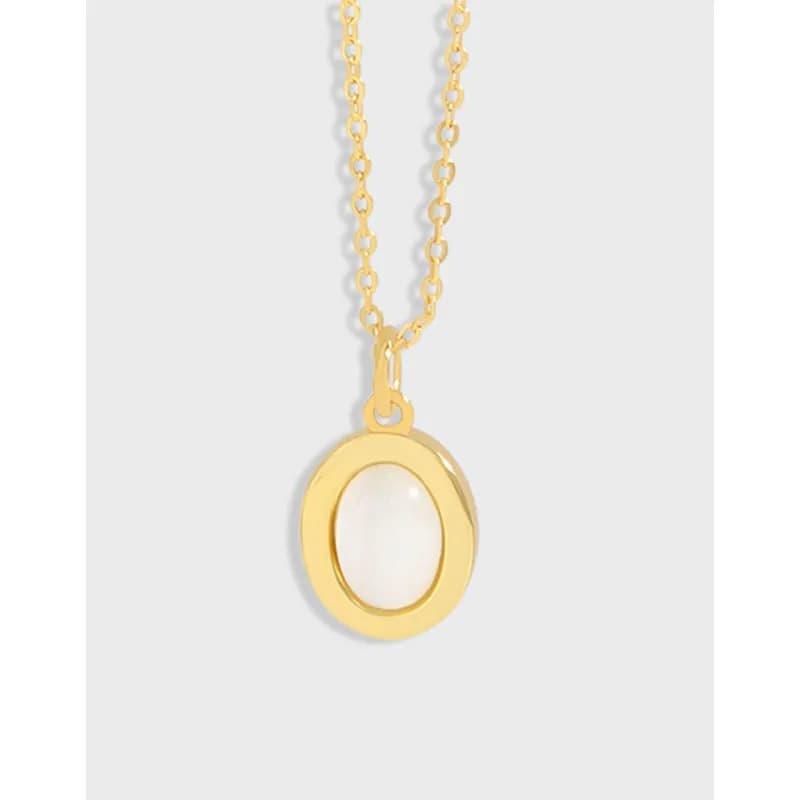 Gold-tone oval bezel pendant with a white oval stone on a delicate chain