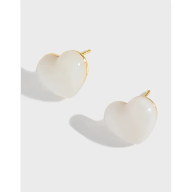 Polished sterling silver heart-shaped earrings with gold-tone edging and posts on a white background.