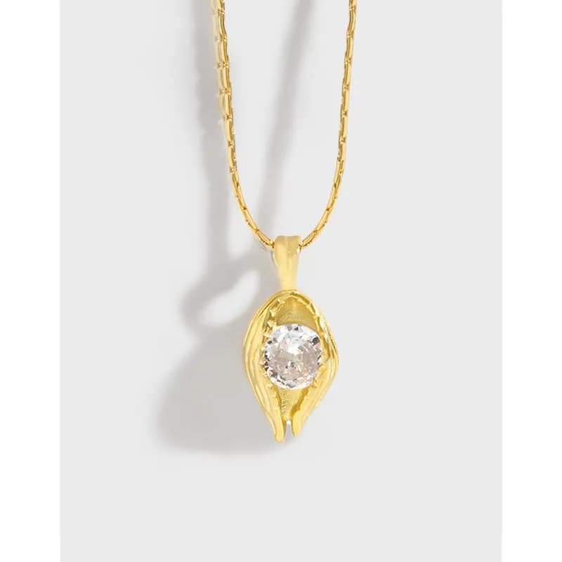 Gold-tone leaf pendant with a round clear stone hanging from a slim chain