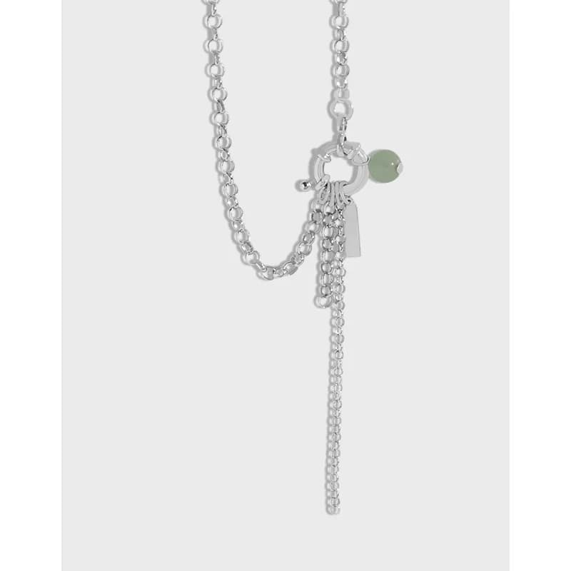 Polished sterling silver multi-chain necklace with a tassel fringe and small charms hanging near the clasp.