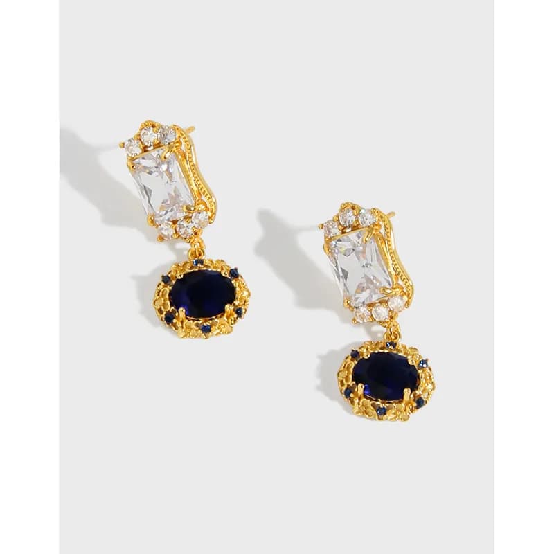 Two polished sterling silver earrings with clear rectangular stones and gold-tone oval drop pendants.