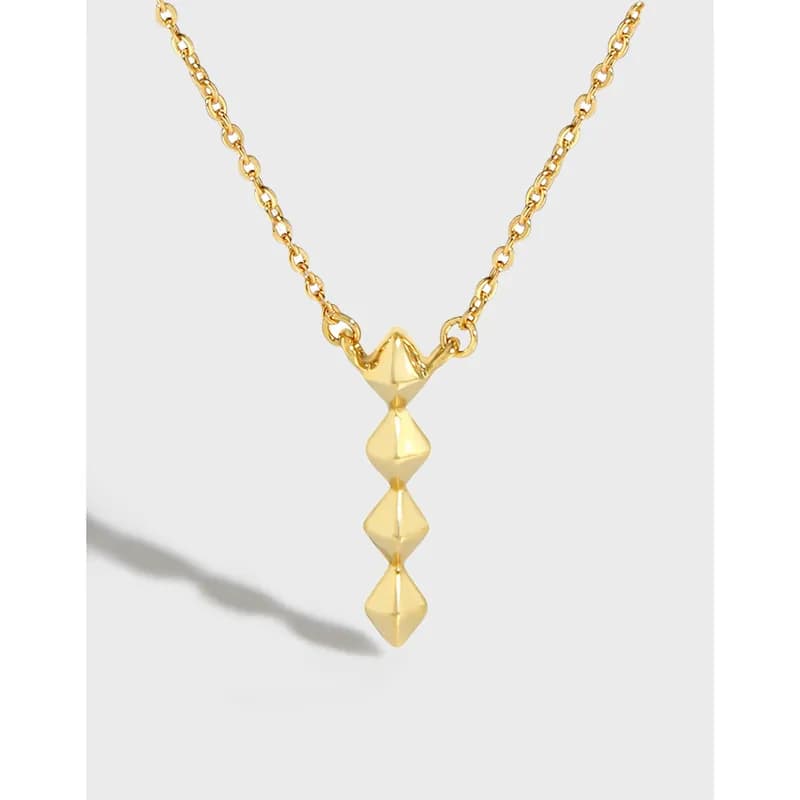Polished sterling silver necklace featuring a four-diamond pendant hanging from a delicate chain against a light background.