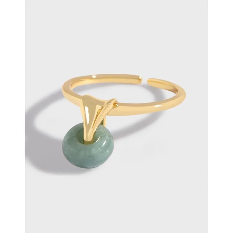 Polished sterling silver ring with a green round bead hanging from a V-shaped setting.