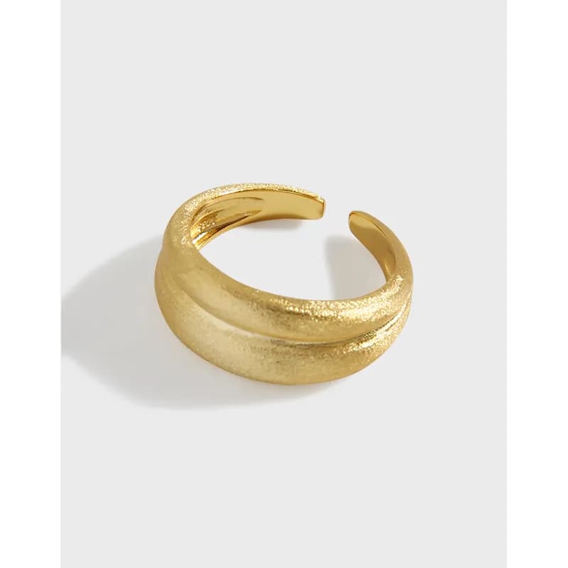 Polished sterling silver double-band ring with an open wrap design on a white surface.