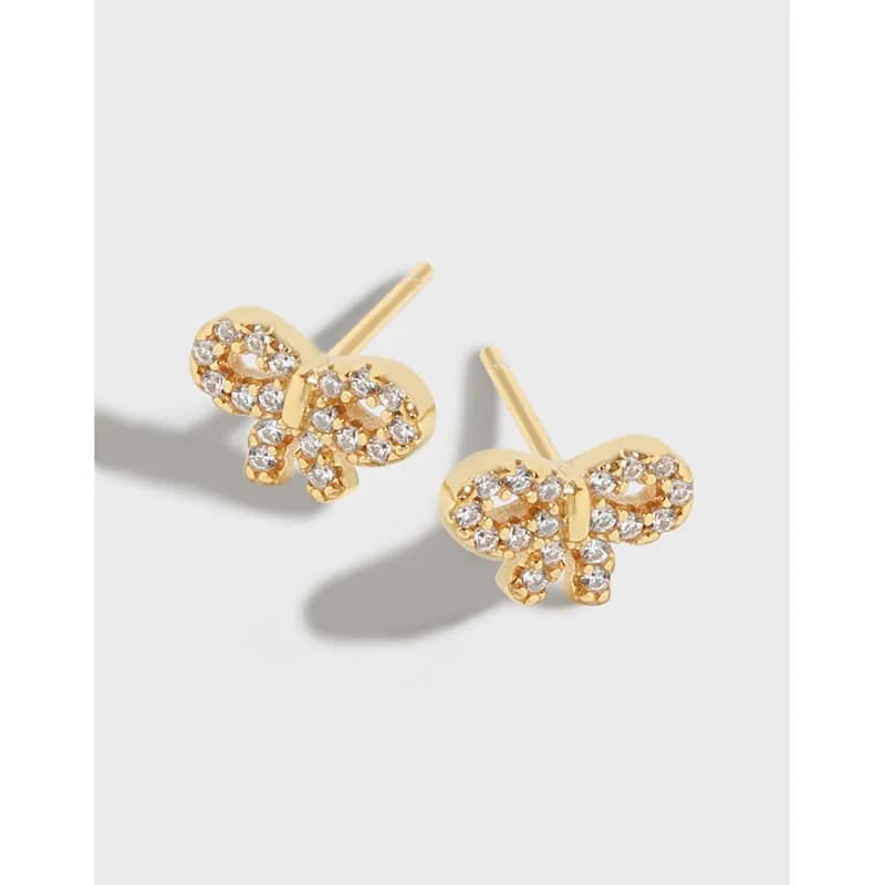 Gold-tone butterfly pavé stud earrings with crystal accents on a light background.