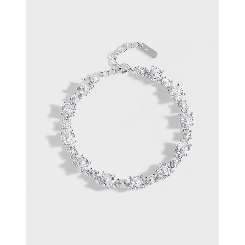 Polished sterling silver bracelet with a row of round stones set along a delicate chain and extender clasp.