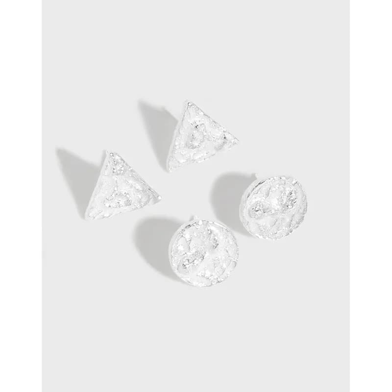 Polished sterling silver textured triangle and circle stud earrings arranged on a light background.