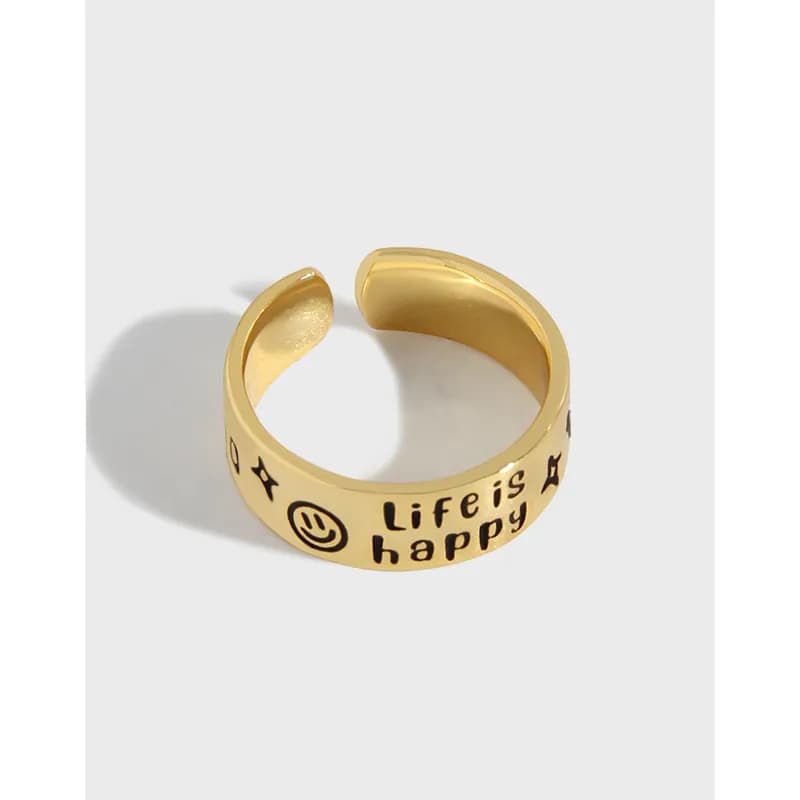 Polished gold-tone open ring with the words Life is happy and a smiley face engraving.