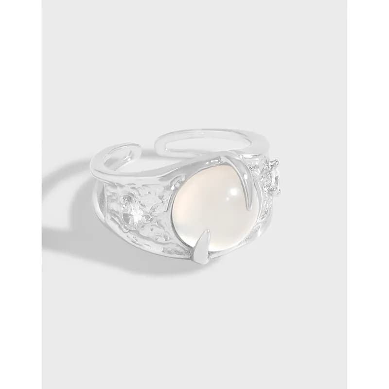 Sterling silver ring with a large pearl cabochon set in a curved crescent bezel and cutout band.