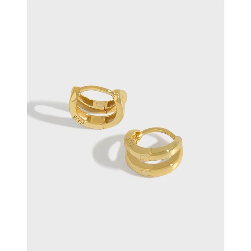 Close-up of polished sterling silver stacked band hoop earrings with a hinged clasp
