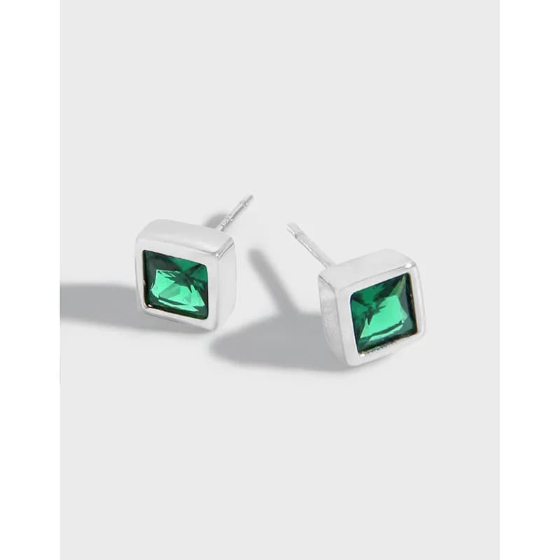 Polished sterling silver square bezel earrings with emerald-green stones on a light background.