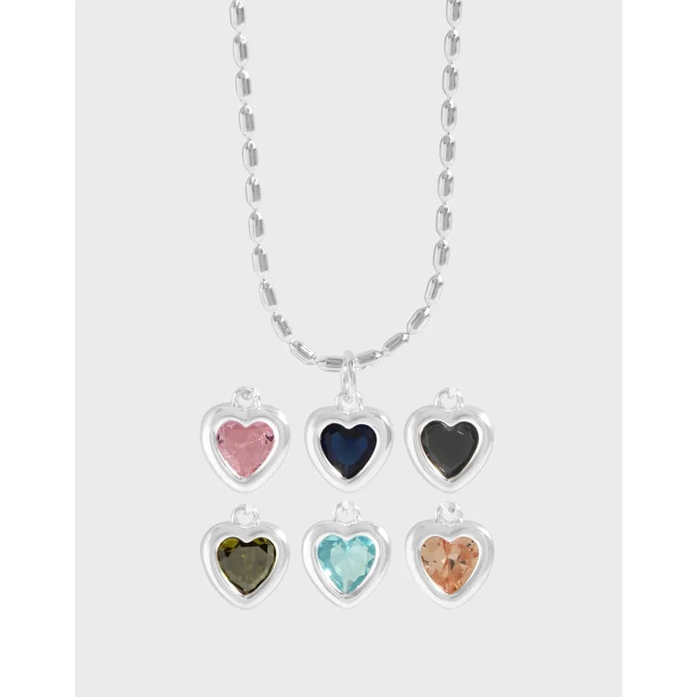 Silver chain with six heart-shaped pendant charms in varied colors hanging from a single necklace