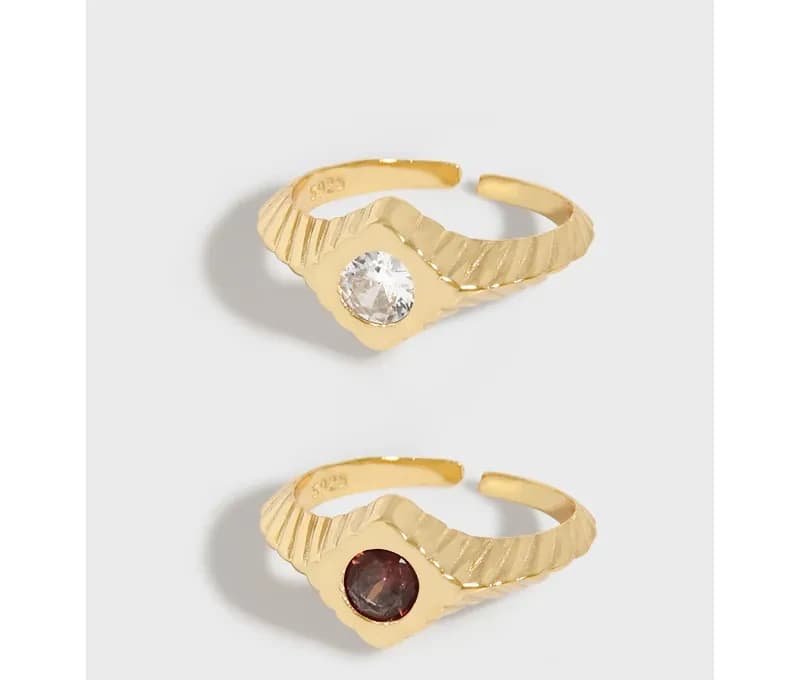 Open, textured ribbed ring in polished sterling silver with a round bezel gemstone on each version.