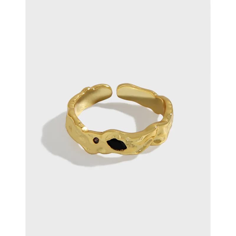 Polished sterling silver ring with an irregular textured band and two small inlays on a light background.