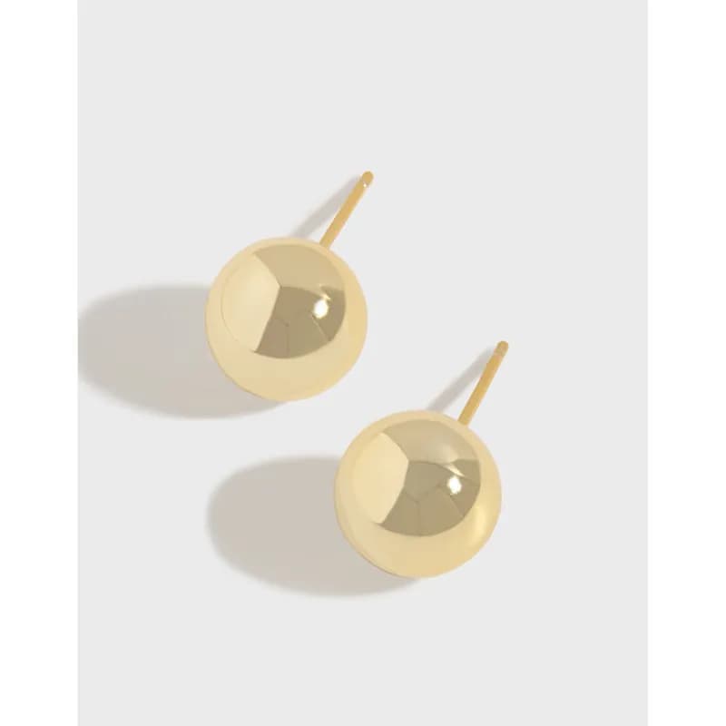 Two polished circular disc earrings with posts worn on a white background.