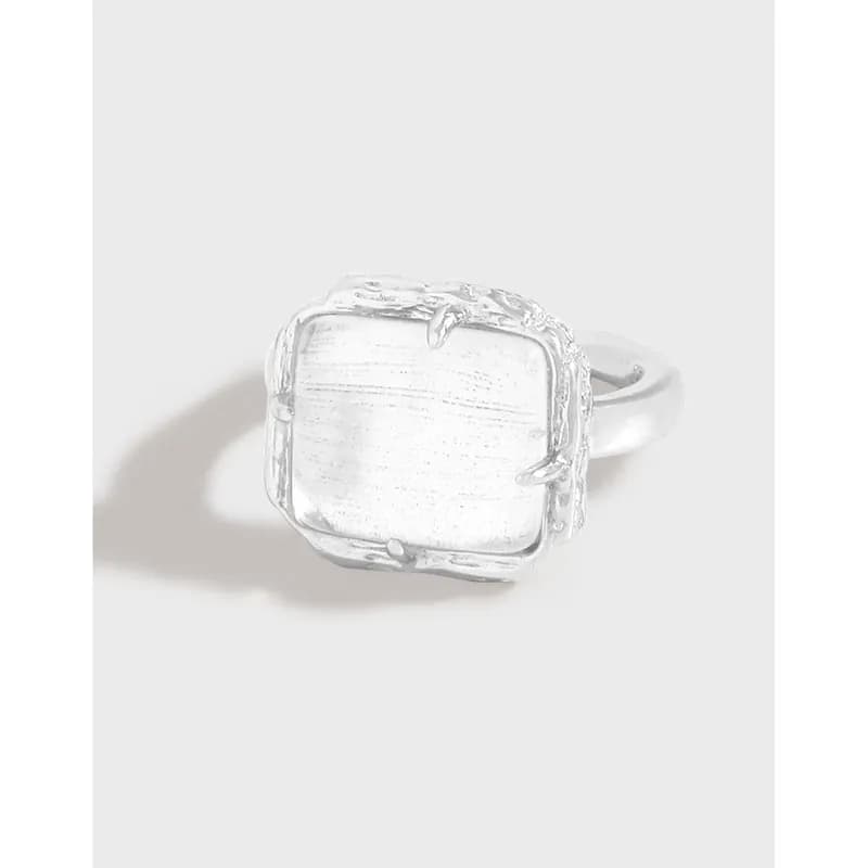 Polished sterling silver square bezel ring with an irregular frame and smooth band.