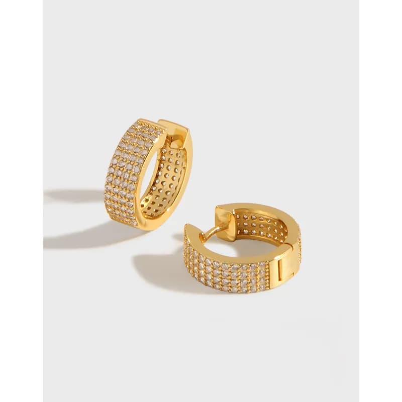 Gold-tone pavé hoop earrings with hinged closure and multiple tiny stones along the outer face.