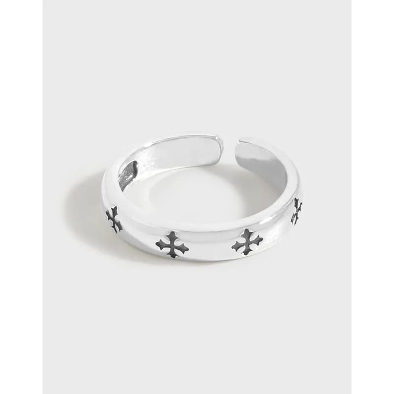 Polished sterling silver open-ring featuring small blackened cross motifs along the band.