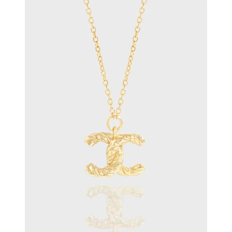 Polished sterling silver chain necklace with a textured double-C pendant
