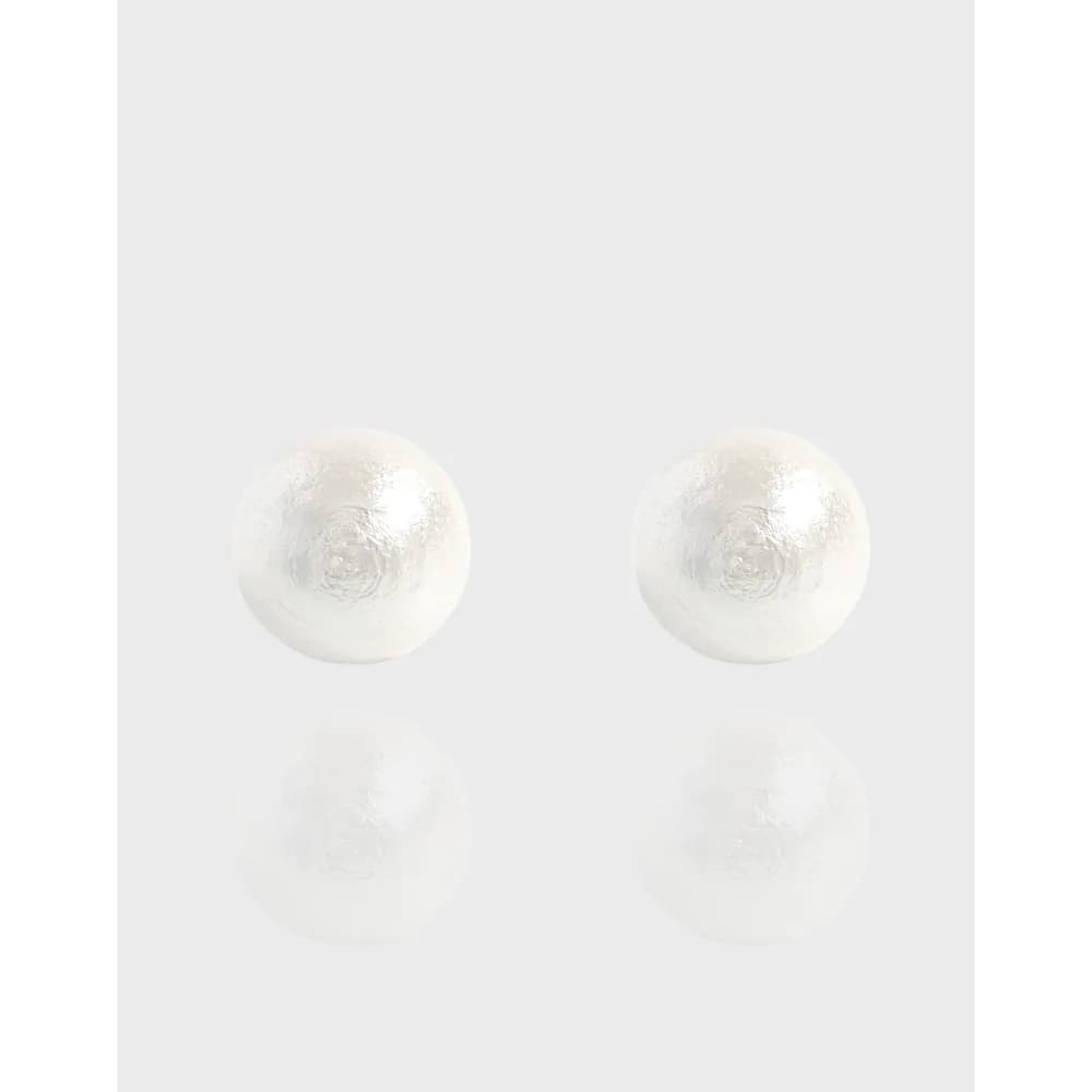 Pair of textured silver disc stud earrings on a light background