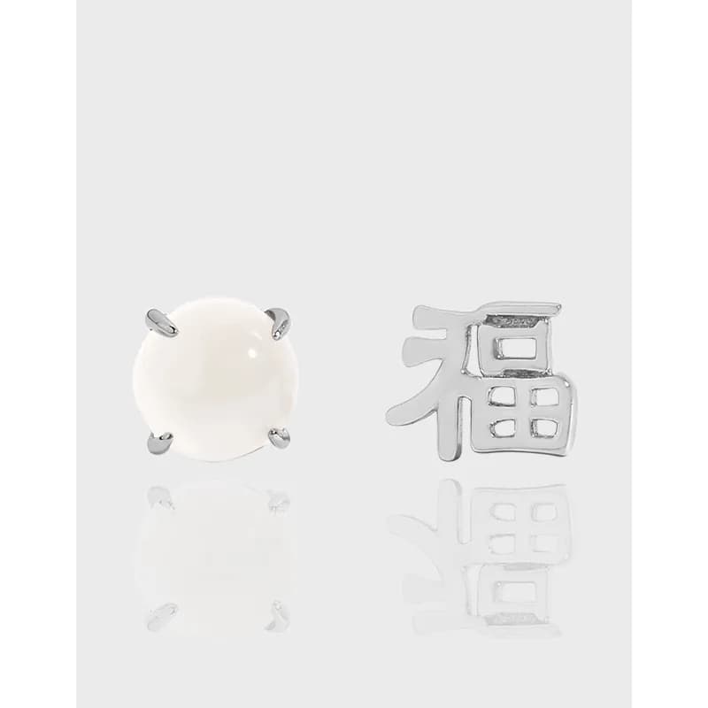 Sterling silver earrings: a white cabochon stone stud and a 福 charm stud in a polished finish.