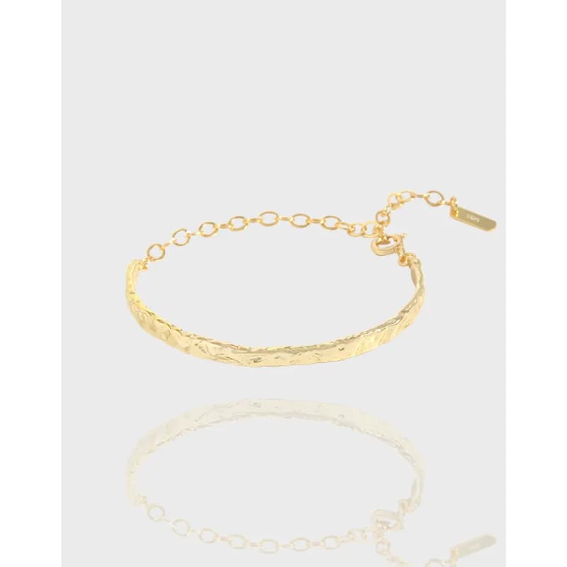 Polished sterling silver hammered arc bracelet with adjustable chain on a light background