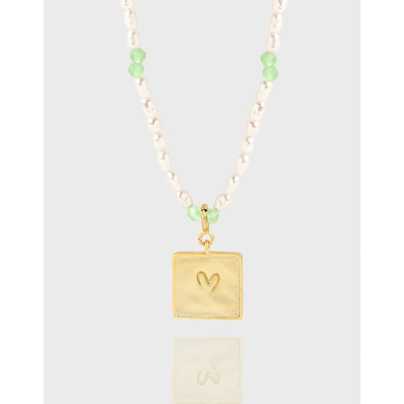 Beaded silver chain with green accent beads and a gold-tone square pendant featuring a heart engraving.
