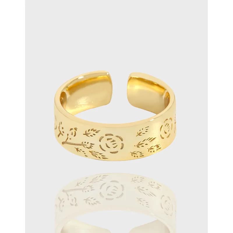 Polished sterling silver floral engraved open-ring on a light background.