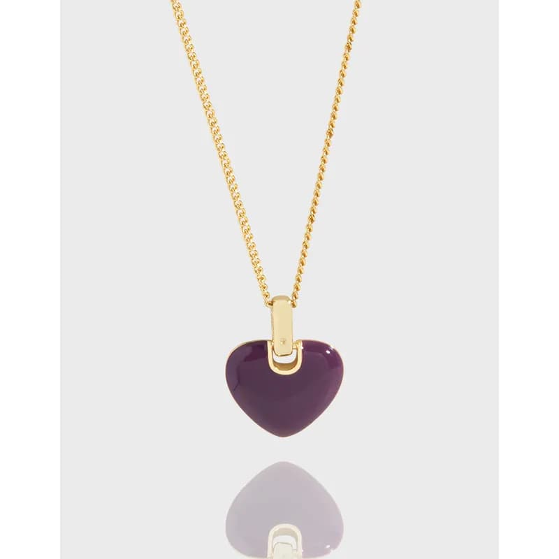 Sterling silver chain with a purple enamel heart pendant against a light background.