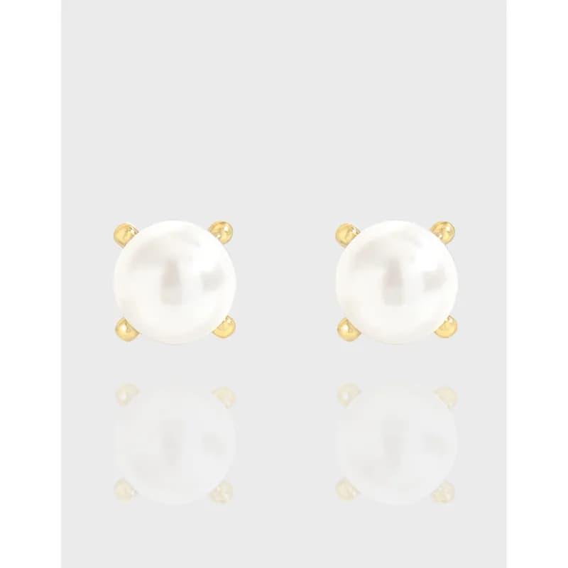 Pair of pearl stud earrings with four gold-tone prongs on a light gray background.