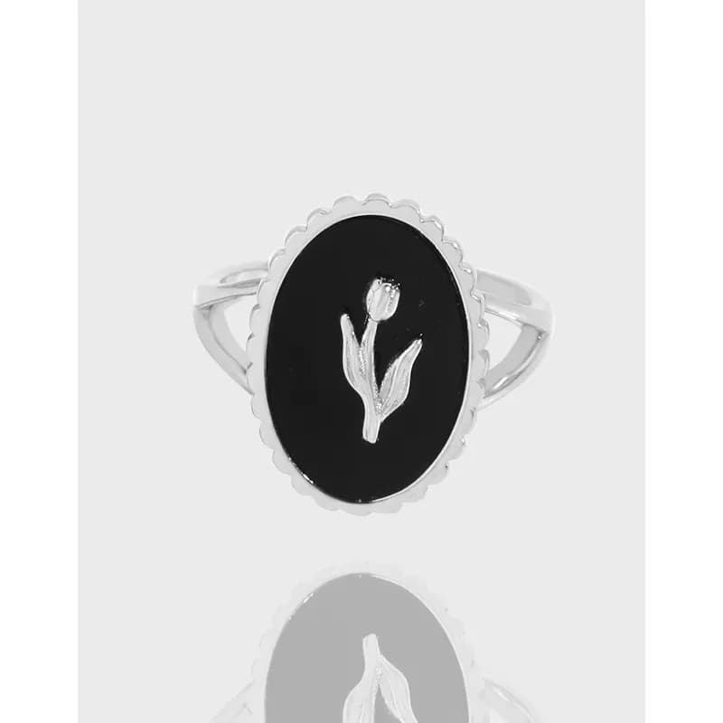 Oval black enamel ring with a silver tulip motif and scalloped bezel