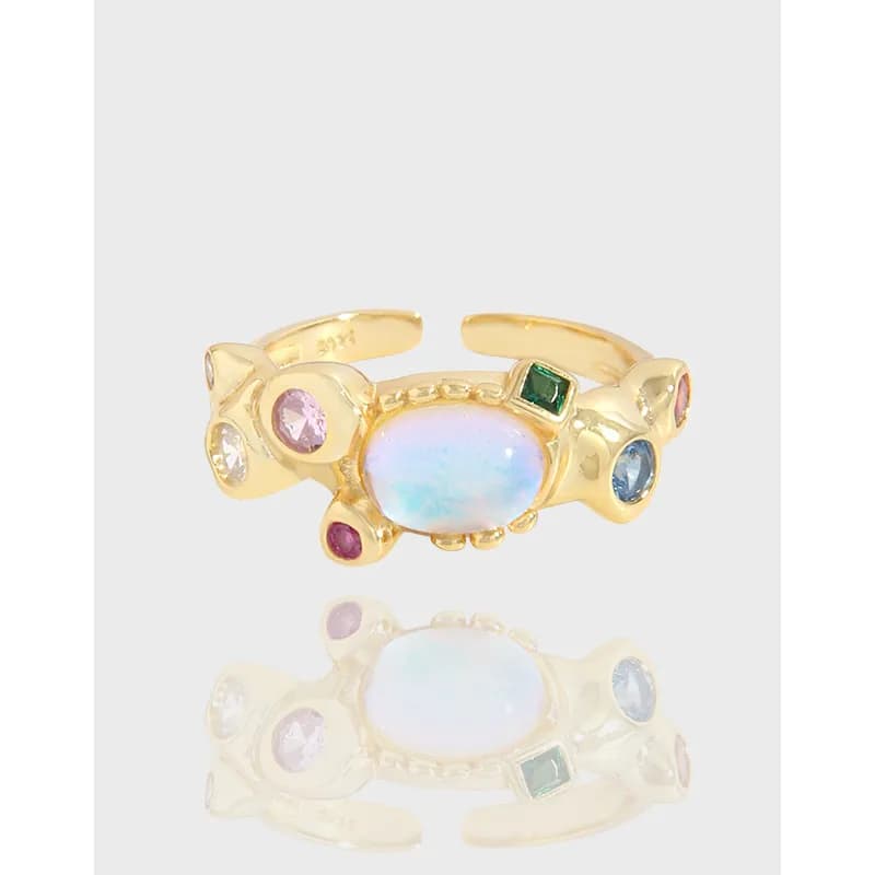 Polished sterling silver ring with a central opalescent cabochon and colorful surrounding stones in a clustered design.
