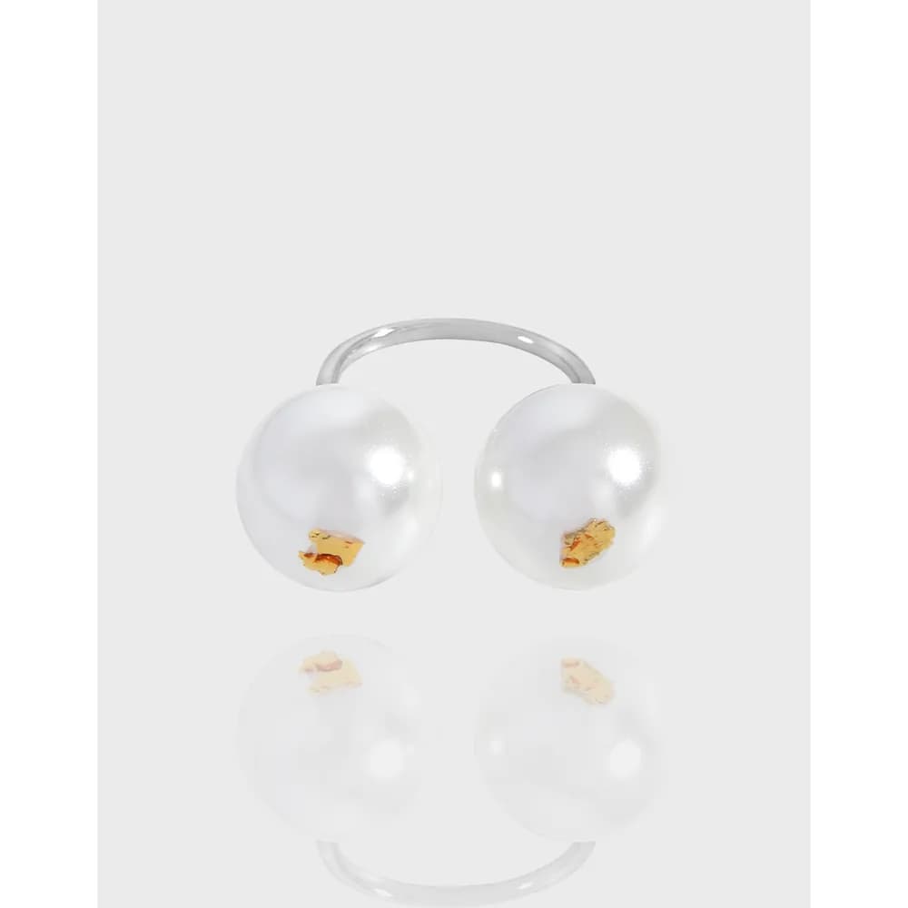 Open sterling silver ring with two large white pearls at the ends.