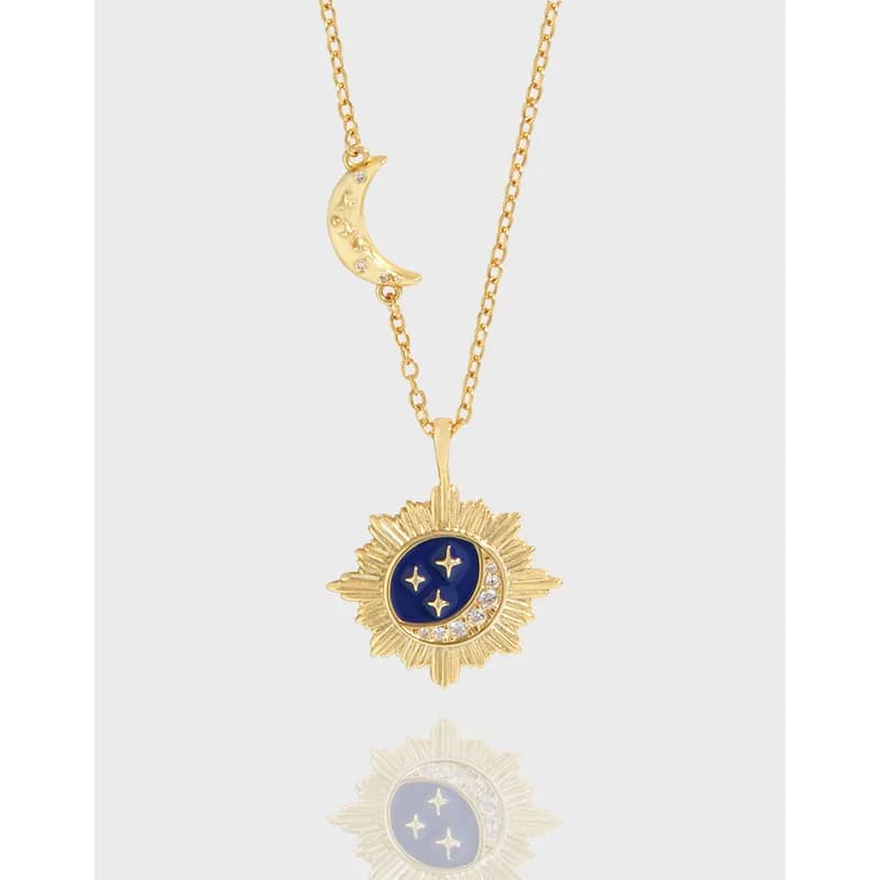 Polished sunburst pendant necklace with blue enamel crescent and star details on a delicate chain.