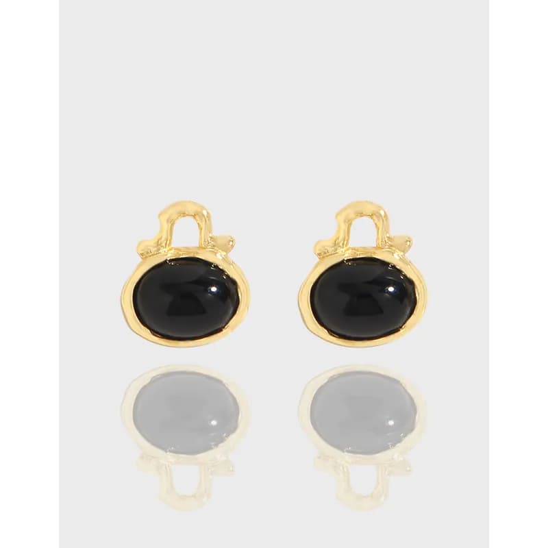 Pair of polished gold-tone earrings with glossy black oval stones set in rounded bezels.