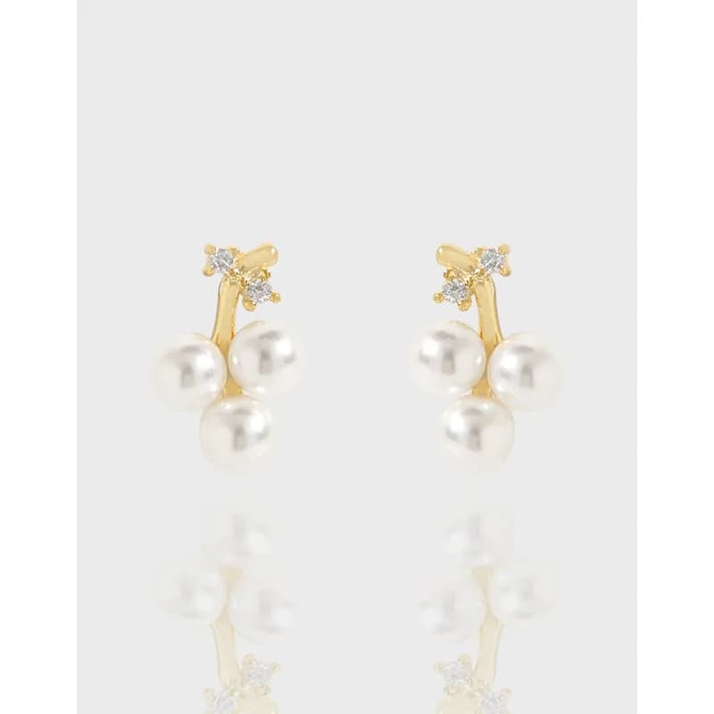Gold-tone pearl cluster drop earrings with three dangling pearls and small crystals at the top.