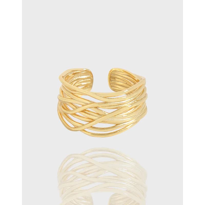 Polished silver interwoven band ring with multiple crossing strands on a neutral background.