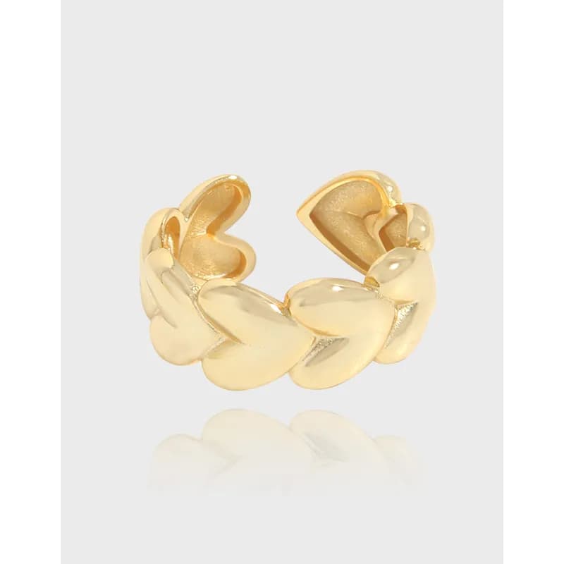 Open ring with interconnected heart-shaped lobes forming a sculptural band in a polished gold finish.