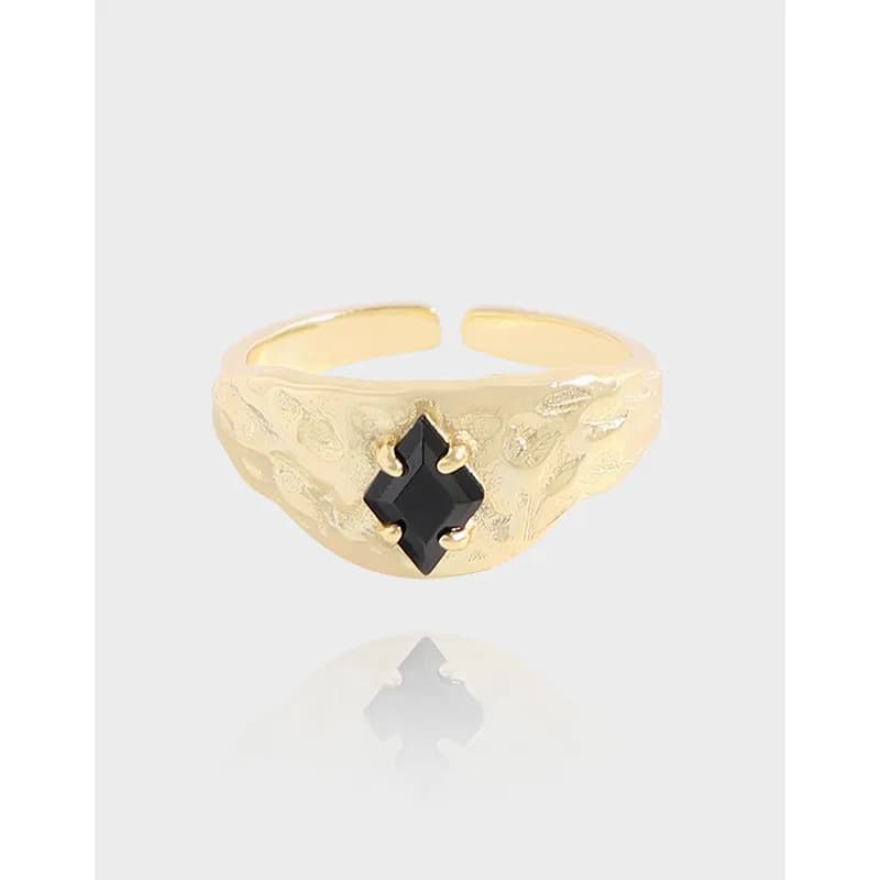 A polished sterling silver ring with a textured band and a squared black stone centerpiece.