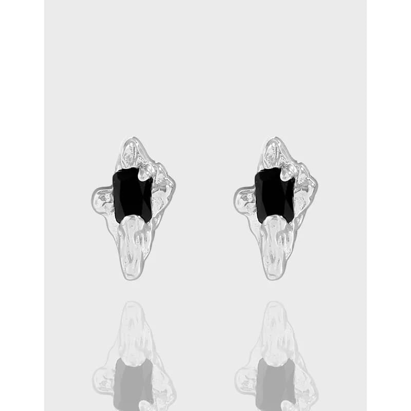 Pair of irregular silver stud earrings with black central stones in a jagged, geode-inspired setting.