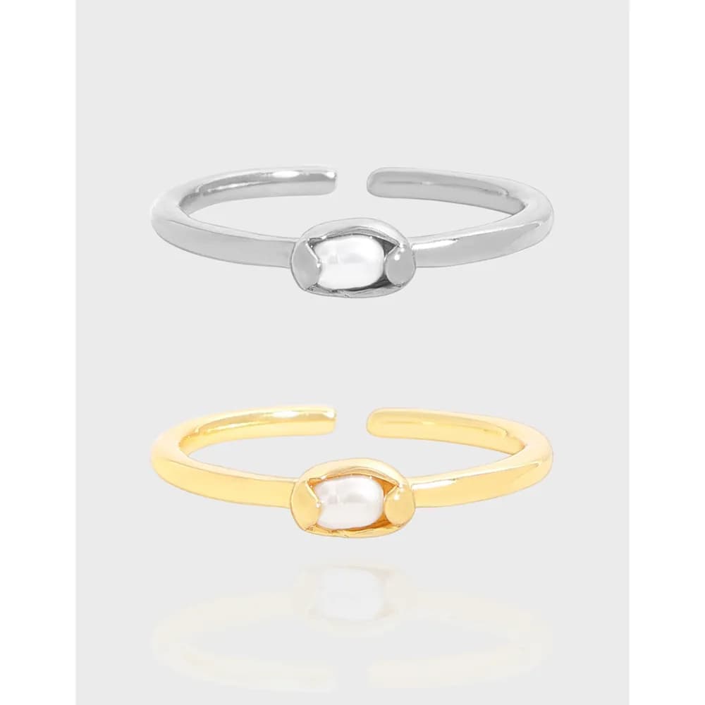 Polished silver ring with a central pearl-like bead in a rounded bezel on an open band
