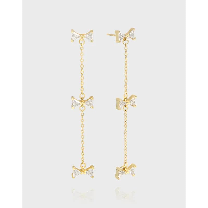 Polished sterling silver bow chain drop earrings with three small bows along a long chain.