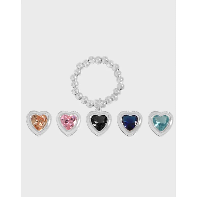 A silver beaded ring with five colorful heart enamel charms in orange, pink, black, blue, and teal