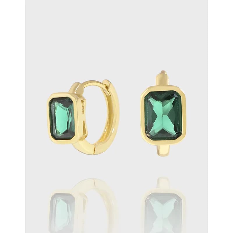Polished sterling silver earrings with rectangular emerald-cut green stones in gold-tone bezel settings.
