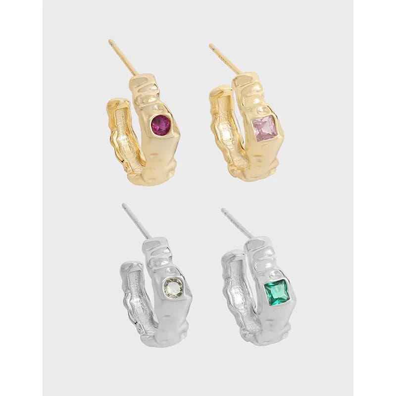 Polished textured hoop earrings in gold-tone and silver-tone with bezel-set stones visible on the outer face.