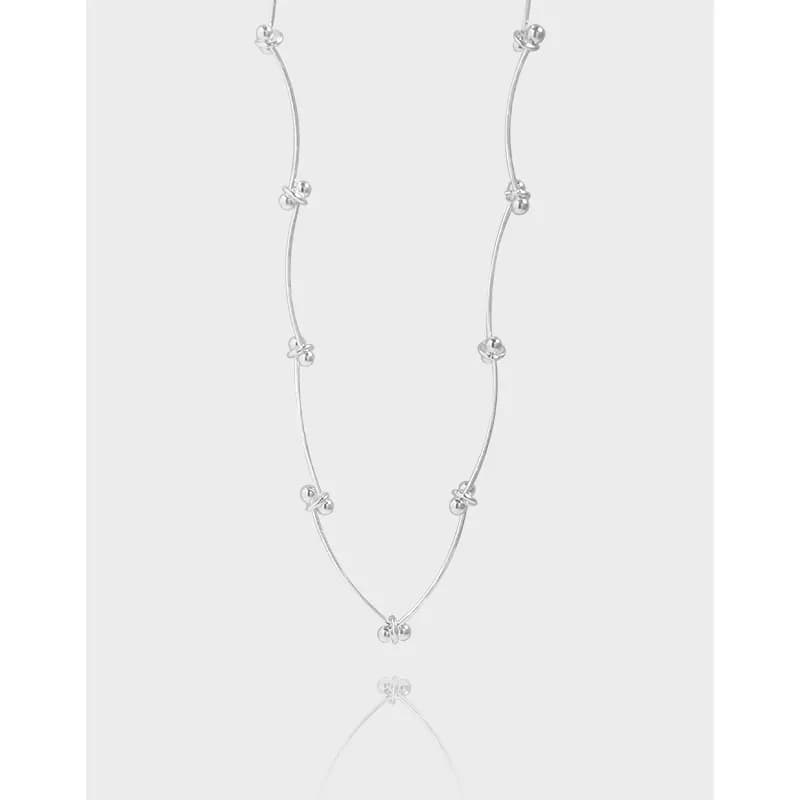 Polished sterling silver double-strand necklace with small knot beads along the curved wires.